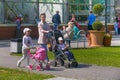 KALININGRAD, RUSSIA - MAY 21, 2016: Unknown mother with a baby carriage strolls along with the children