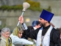 KALININGRAD, RUSSIA. The orthodox priest consecrates believers with the help an aspergillum. Easter tradition