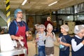 KALININGRAD, RUSSIA. Male master hands out chocolate mass to children for tasting. Children `s tour to the Belgostar chocolate fa