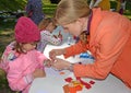 KALININGRAD, RUSSIA. The teacher helps the child to do applique. Children`s master class in the open air