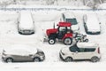 Kaluga, Russia - December 8, 2022: Tractor shoveling snow with a bucket in a car parking lot after a snowfall in winter Royalty Free Stock Photo