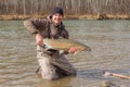 Kalum River, British Columbia, Canada - April 11th, 2017: A fly fisherman holding a big steelhead in the spring sun Royalty Free Stock Photo