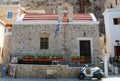 A scooter parked in front of Little Greek Chapel with Greek Flag. July 16,2013 in Kalymnos, Greece