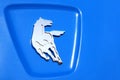 Kamaz logo close up, shining running silver horse on blue background