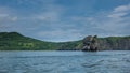 Kamchatka coast against the background of blue sky and ocean. Royalty Free Stock Photo