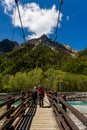 KAMIKOCHI, JAPAN - MAY 24 2023: Hikers crossing the Myojin suspension bridge over the Azusa River in Kamikochi, Nagano, Japan