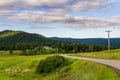 KAMLOOPS, CANADA - JULY 10, 2020: country road through the medow landscape with house on background and cloudy sky Royalty Free Stock Photo