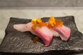 Kampachi sushi with Uni and Ikura on top on black ceramic plate Royalty Free Stock Photo
