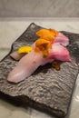 Kampachi sushi with Uni and Ikura on top on black ceramic plate Royalty Free Stock Photo