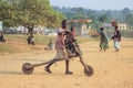 Home-made wooden children`s scooters are used to carry goods by children in Africa. Poor African childhood and child labor. Stree