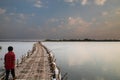 Man crosses old traditional bamboo wooden bridge across Mekong river