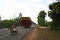 A motorcycle runs on National Highway 6 in Cambodia loading lots of rattan boxes