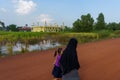 Kampot. Cambodia. Veiled Muslim woman walking in front of the mosque
