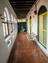 A corridor with arched windows lined with chairs in an old vintage heritage house