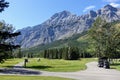 A whole view of a spectacular par 4 with people teeing off with the mountains in the background on a summer day in Kananaskis