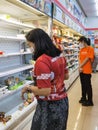 KANCHANABURI,THAILAND-AUGUST 14,2021 : Unidentified woman choose food on shelves mostly empty with only a few packages of food