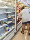 KANCHANABURI,THAILAND-AUGUST 11,2021 : Unidentified woman choose food on shelves mostly empty with only a few packages of food