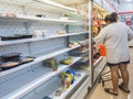 KANCHANABURI,THAILAND-AUGUST 11,2021 : Unidentified woman choose food on shelves mostly empty with only a few packages of food