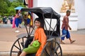 Kanchanaburi, Thailand, 09.09.2019: Beautiful Thai girl in traditional Thai, Siamese dress in an old rickshaw in front of the