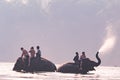 KANCHANABURI, THAILAND - FEB, 2018 : tourism ride the elephant to take a shower at Kwai river, travel and adventure activity in Th