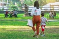 KANCHANABURI, THAILAND-JANUARY 11,2020 : Back view of unidentified Asian mother and her son walking side by side together on lawn