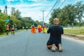 KANCHANABURI, THAILAND-OCTOBER 6,2019 : Back view of unidentified sport photographer sit to take a picture marathon runners in
