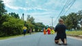 KANCHANABURI, THAILAND-OCTOBER 6,2019 : Back view of unidentified sport photographer sit to take a picture marathon runners in