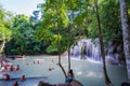 Kanchanaburi, Thailand-October 14, 2023 : Tourists wear life jackets while playing in waterfalls on holiday, beautiful waterfall