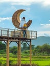 KANCHANABURI-THAILAND, SEPTEMBER 13, 2020 : Happy young couple take photo with crescent moon chair made of rattan for relaxation