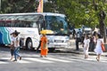 Kandy, Sri Lanka: 03/19/2019 : City center with tourist coach and buddhist monk crossing the road shaded by yellow umbrella