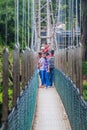 KANDY, SRI LANKA - JULY 18, 2016: People at a suspension foot bridge in Peradeniya Royal Botanical Gardens near Kandy