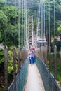 KANDY, SRI LANKA - JULY 18, 2016: People at a suspension foot bridge in Peradeniya Royal Botanical Gardens near Kandy