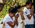 KANDY, SRI LANKA - JULY 19, 2016: White clothed buddhist pilgrims pray at Wel Bodiya with Bodhi tree during Poya Full