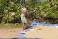 Kandy, Sri Lanka: 03/20/2019: Rice farmer raking rice crop to dry in the sun