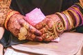 The jeweled and henna decorated hands of a young bride at a village wedding in Jammu and Kashmir