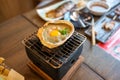 Kani miso Crab carapace grilled on a small charcoal stove On a wooden table