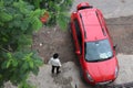 Car driver standing outside his red color good looking SUV hatchback car.