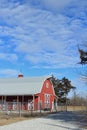 Kansas Red Barn with blue sky and white clouds with tree`s and a fence out in the country. Royalty Free Stock Photo