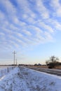 Kansas Snowy Highway with power lines, snow, and a blue sky that`s bright and colorful. Royalty Free Stock Photo