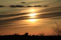 Kansas sunset with a tree silhouette and clouds that\'s bright and colorful