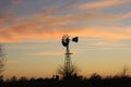 Kansas Windmill silhouette with a colorful Sunset with clouds and the sun out in the country. Royalty Free Stock Photo