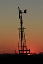 Kansas Windmill Silhouette at Sunset with clouds and Trees out in the country