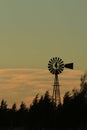 Kansas Windmill sunset with a tree silhouette with a colorful green sky
