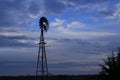 Kansas Windmill sunset with a tree silhouette with a colorful sky