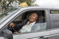 Karakol, Kyrgystan, August 12 2018: Friendly Taxi driver in his old rusty car in Karakol Royalty Free Stock Photo