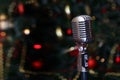 Karaoke microphone on the background of a Christmas tree. New year or Christmas. Concept of recreation and entertainment. Singing