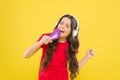 Karaoke star. Cute little girl pretending singing karaoke on yellow background. Adorable child performing karaoke song Royalty Free Stock Photo