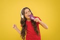 Karaoke star. Cute little girl pretending singing karaoke on yellow background. Adorable child performing karaoke song Royalty Free Stock Photo