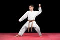 Karate boy in white kimono fighting isolated on black background Royalty Free Stock Photo