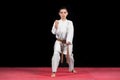 Karate boy in white kimono fighting isolated on black background Royalty Free Stock Photo